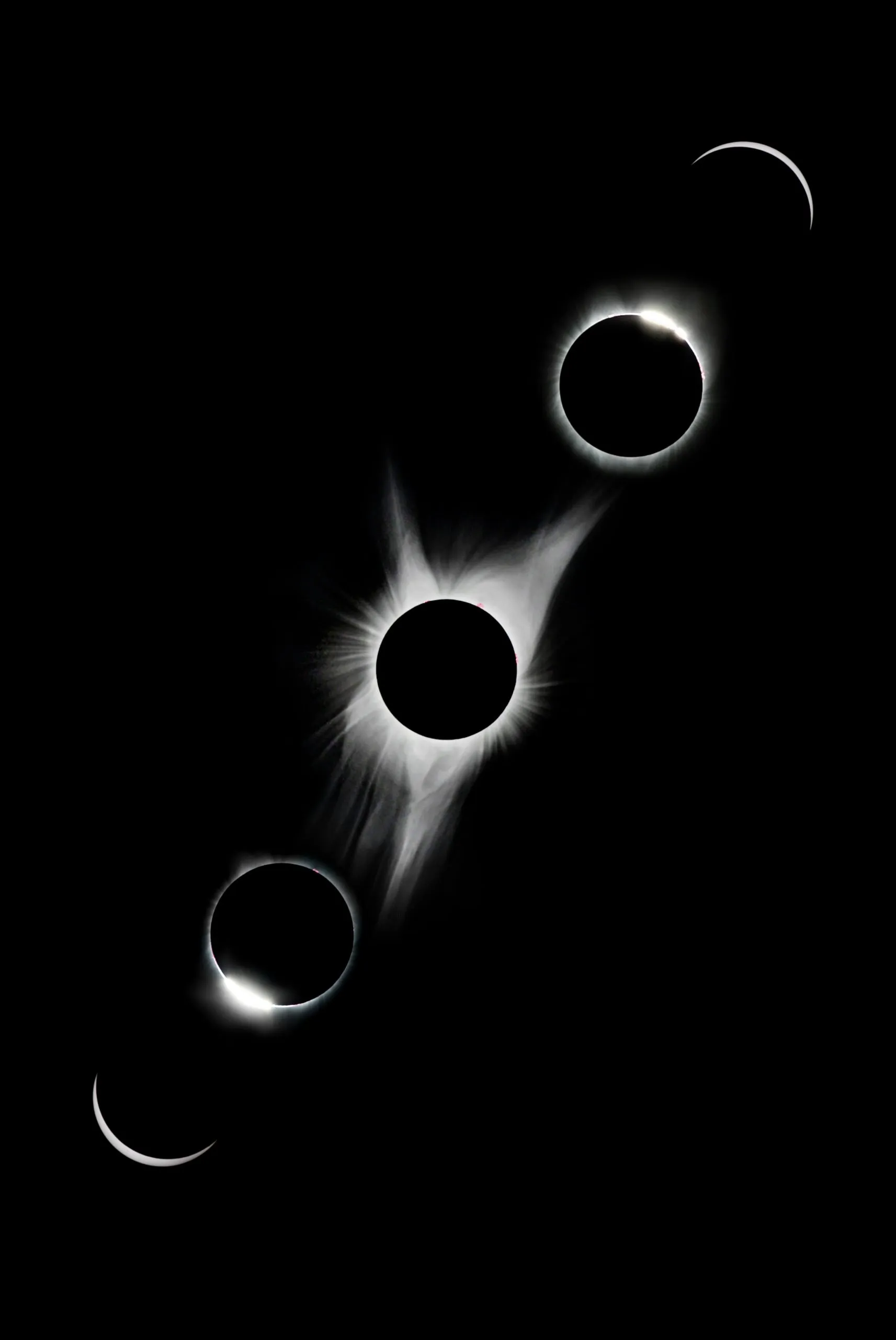 Four phases of a total solar eclipse against a black background, showing the progression from partial eclipse to totality and back to partial.